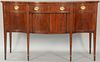 Custom mahogany Federal style sideboard having shaped top over center drawer over two doors and bottle drawers flanked by drawers an...