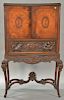 Carved walnut victrola cabinet having two burl walnut doors over elaborate carved figural drawer with base carved with horse carriag...