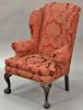 Margolis mahogany Chippendale style upholstered wing chair set on shell carved cabriole legs ending in ball and claw feet.