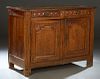 French Provincial Carved Oak Louis XVI Style Sideboard, 19th c., the four board top over two setback frieze drawers, above two fielded panel cupboard 