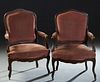 Pair of French Louis XV Style Carved Walnut Fauteuils, early 20th c., the canted arched reeded upholstered back over upholstered arms and a bowed cush