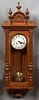 Continental Carved Walnut Regulator Wall Clock, c. 1900, time and strike, the finial mounted crest over a steel dial, the pendulum door mounted with e