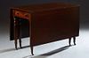English Victorian Carved Mahogany Drop Leaf Dining Table, 19th c., with one end frieze drawer, on turned tapered reeded legs with brass cap casters, H