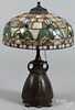 Art Nouveau patinated white metal table lamp, early 20th c., with a leaded glass shade, 23'' h.