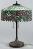 Patinated bronze table lamp, early 20th c., probably Handel, with a leaded mosaic glass shade
