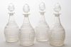 SET OF FOUR MOLDED GLASS DECANTERS AND STOPPERS