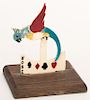 Parrot Trump Indicator. Circa 1930. Celluloid parrot on wood base. Tail points to the suit bid. Excellent.