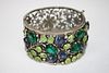 Fine costume bangle having floral openwork back and jeweled floral front. 1½" wide.