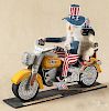 Carved and painted outsider art Uncle Sam riding a Harley Davidson motorcycle, 12 1/4'' h.