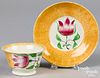 Yellow spatter cup and saucer with tulip.