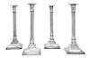 * A Set of Four George III Sheffield-Plate Candlesticks, Circa 1800, on stepped square bases, engraved with foliate swags, risin