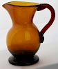 late 18th c free blown Stiegel type Mid Western cream pitcher, amber, open pontil, ht 4 1/2”, dia 2 3/4”, Dr Oliver Eastman c