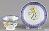 Miniature blue spatter cup and saucer with yellow tulip decoration.