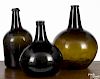 Three early olive amber glass bottles, 19th c., 11 1/2'' h., 13 1/4'' h., and 14'' h.