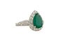 Lady's 18K White Gold Dinner Ring, with a pear shaped 2.2 carat emerald atop a conforming border of round diamonds, the shoulders of the band with thr