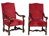 Pair of French Louis XIII Style Carved Walnut Fauteuils a la Reine, 20th c., the arched canted upholstered rectangular back over curved scrolled arms,