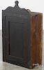 Stained pine hanging cupboard, 19th c., with a lollipop crest and paneled door