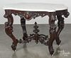 Victorian marble top center table, late 19th c., with a turtle-shaped top, a carved apron, and legs