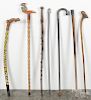 Seven walking sticks, to include several carved folk art examples.