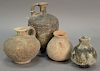 Four ancient stone and clay urns including a terracotta handled vase, two stone handled jugs, and a small molded vase. ht. 3 3/4in. ...