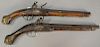 Two flintlock pistols with inset brass plaques and carved wood stock. lg. 19in. & 20in.