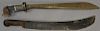 Two early wood handled machetes, one with carved face and silver mount (face has chip). lg. 22in., lg. 24in.