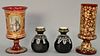 Four piece art glass group to include a pair of small black glass vases with white enamel (ht. 4"), ruby glass vase with gilt scroll...