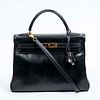 Hermes Kelly Retourne 32 Handbag, c. 1998, in black calf leather with golden hardware, opening to a matching black leather lined interior with two sid