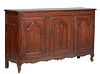 French Provincial Louis XV Style Carved Walnut Sideboard, 19th c., the stepped rounded edge and corner top over two large fielded panel cupboard doors