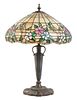 An American Leaded Glass and Bronze Lamp, THE MOSAIC SHADE COMPANY, CHICAGO, the shade having a floral pattern, raised on an 