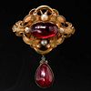 VICTORIAN GARNET AND PEARL BROOCH. set with a large cabochon garnet surrounded by four pearls in an open work design. with a garnet and diamond drop. 