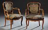 Pair of French Carved Beech Louis XV Style Fauteuils, early 20th c., the canted floral carved upholstered back to upholstered arms, above a bowed seat