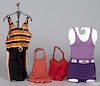 Four vintage children's bathing suits, together with a wrought iron counter store display rack