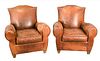 A Pair of Brown Leather Easy Chairs and Ottomans