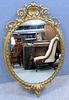 Oval gilt framed mirror with beaded border and scrolling decoration, 112cm x 69cm,