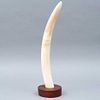 COLMILLO. SXX. Marfil de elefante, sin tallar; con base de madera. Ligeros detalles de conservación. 47 cm de longitud.