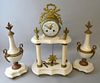 White marble and gilt metal clock garniture with white porcelain dial and Arabic numerals.