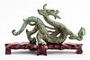 Chinese dragon bronze sculpture with verdigris patina raised on wooden pedestal, apparently unsigned. Sculpture only: 5" H x 9.25" W x 2.5" D.