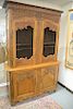 Louis XV fruitwood cabinet in two parts, upper section with carved cornice molding and floral carved top section over two gri