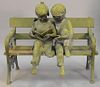 Bronze figural group with a young boy and girl on a park bench reading an alphabet book. 
ht. 38in., lg. 46in.