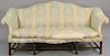 George II sofa having shaped camel back and rolled arms with serpentine front rail on molded front legs with stretcher base a