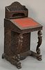 Teak pierced carved Davenport desk having slant lid and carved bird supports on dragon carved base, side with door opening to