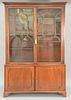 George III mahogany breakfront in two parts, upper portion with arched top glazed doors on lower portion with two doors all s