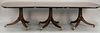 George III mahogany triple pedestal dining table set on three plain turned pedestals, each on three downswept members ending
