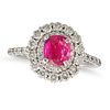 A RUBY AND DIAMOND CLUSTER RING in platinum, set with a cushion cut ruby of 1.05 carats in a doub...