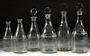 ASSORTED FREE-BLOWN AND ENGRAVED GLASS PRUSSIAN-FORM DECANTERS, LOT OF SIX