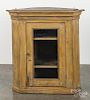 Painted hard pine hanging corner cupboard, early 19th c., retaining a mustard surface, 39'' h.
