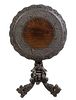 An Anglo-Indian Carved Hardwood Tilt-Top Table Height 30 3/4 x diameter 28 1/4 inches.