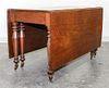 An American Empire Cherry Drop Leaf Table Height 29 x length 54 inches.