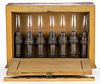 ROBERT MITCHELL CO. BRONZE CANDLE LAMPS IN WOODEN CABINET DISPLAY BOX, SEVEN-PIECE SET